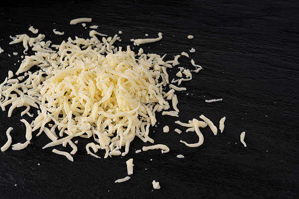istock Grated mozzarella cheese on black background. Shredded mozarella texture 2250319751
