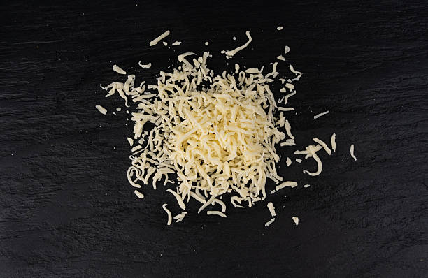 istock Grated mozzarella cheese on black background. Shredded mozarella texture 2250320130