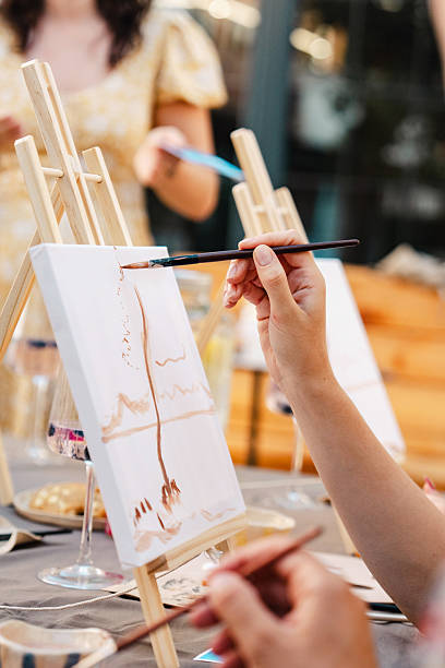 Art class outdoors with people painting on canvas