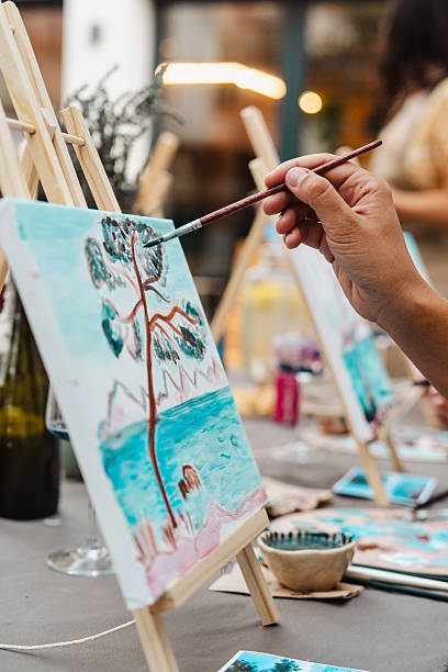 istock Art class outdoors: painting a landscape on a small canvas with a brush 2250321985