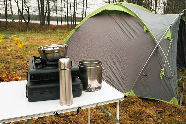 istock Lakeside camping scene, Camp setup by tranquil waters, Arranged campsite area near peaceful lake forest. Serene campsite prepared for outdoor meal experience. Quiet. Campground basic cooking amenities 2250323013