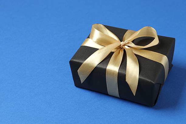 istock Beautiful gift box with a golden bow on color background 2250327790