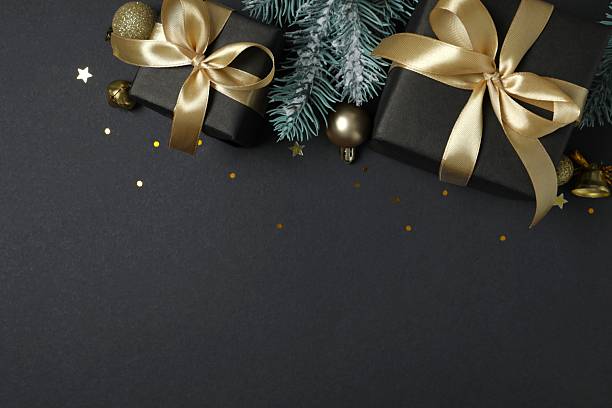 istock Beautiful gift boxes tied with golden bows on black background 2250329080