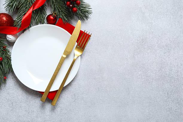 istock Elegant holiday table setting with white plates, gold flatware, red napkin, Christmas and New Year's celebrations 2250329155