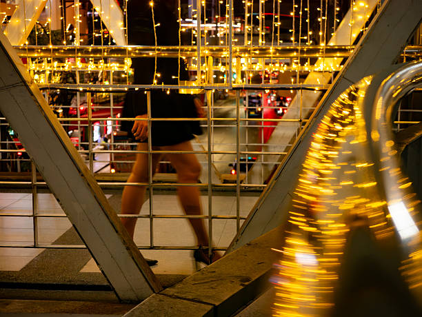 Modern Bridge Walkway with Golden String Lights: Urban Architecture Night View with Festive Illumination and Glass Railing