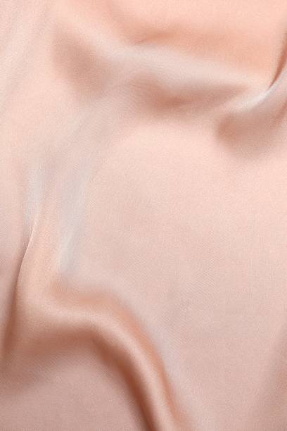 istock Beige silk satin. Shiny smooth fabric. Soft folds. Luxury background with space for design. Flat table, top view 2250329216