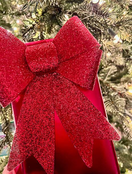 istock Red ribbon Christmas present by the holiday lights 2250331991