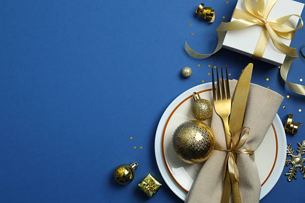 istock Festive Christmas table setting with plate, cutlery and decorations on color background 2250337159