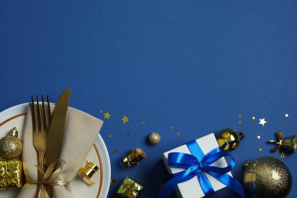 istock Festive Christmas table setting with plate, cutlery and decorations on color background 2250337232