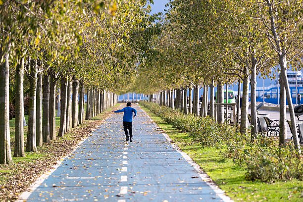Small and overweight boy jogging in the park