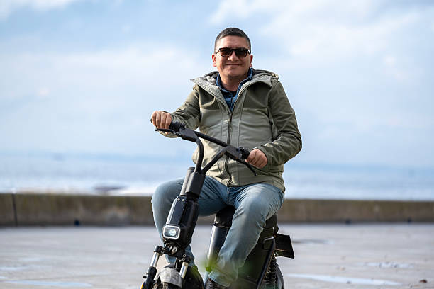 A man is driving a rented scooter in the park