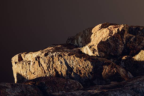 3d presentation pedestal or dais made of rock illuminated by sunlight. 3d rendering of mockup of presentation podium for display or advertising purposes