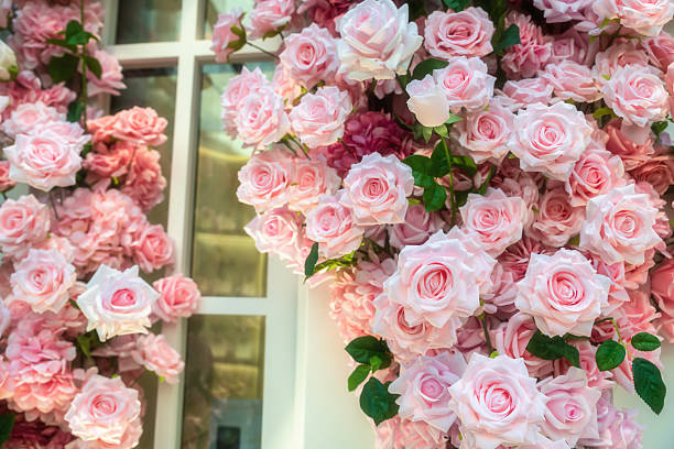 Artificial pink roses decor at facade window building at Xintiandi, Shanghai, China. Fake flower at Historic European-style architecture.