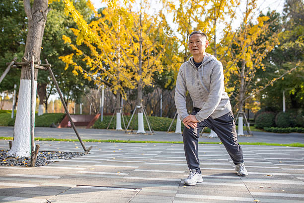 An elderly Asian man doing morning exercises in the park
