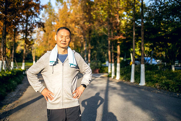 Senior man runner holding towel around neck