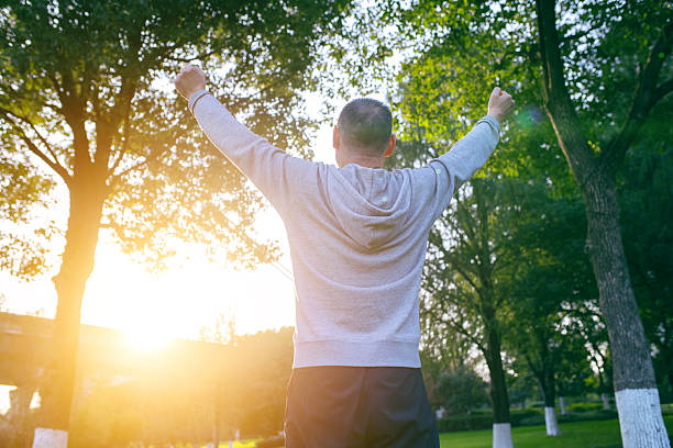 An elderly Asian man doing morning exercises in the park