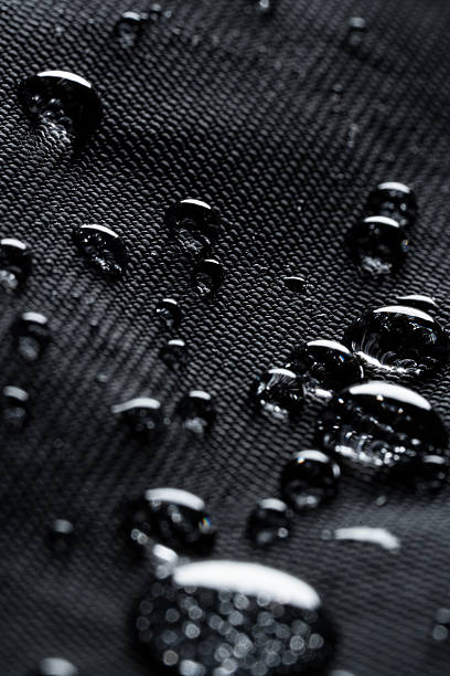 istock Dramatic Macro of Reflective Water Droplets on Black Hydrophobic Fabric 2250354476