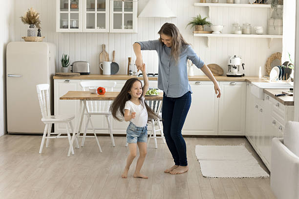 istock Mother and daughter having fun, dancing in the kitchen 2250355207