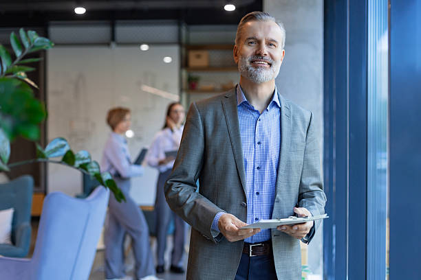 istock Smiling handsome businessman manager standing in office with tablet 2250361615