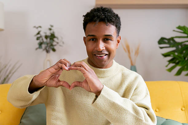 istock Young man showing heart gesture with hands smiling 2250363139