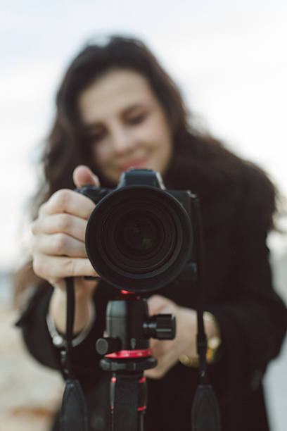 istock Female photographer adjusting professional camera 2250364227