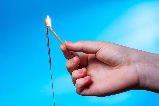 istock A child's hand holding a lit match tries to light a sparkler. 2250368062