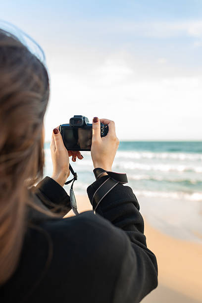 istock Smiling female photographer holding a camera on a 2250369591