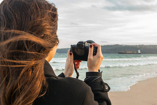 Smiling female photographer holding a camera on a