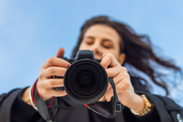 istock Low-angle view of a female photographer holding a 2250370868