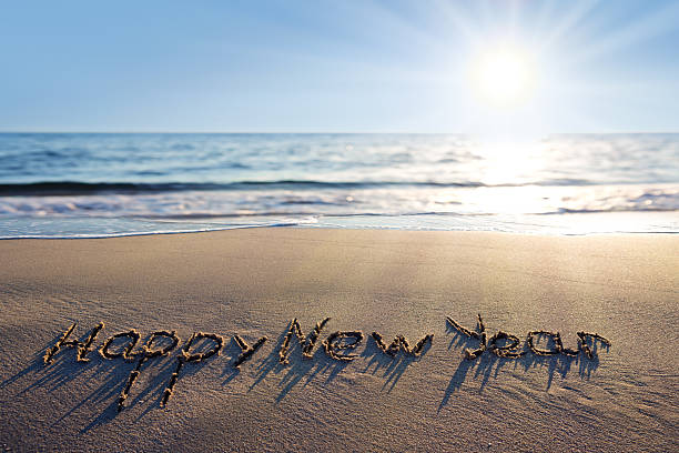 istock Happy New Year lettering on the sunny beach sand. 2250376966