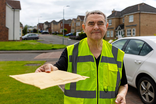 istock Courier Offering Padded Mailer to Homeowner During Delivery 2250381476