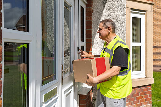 istock Side View of Courier Pressing Doorbell While Holding Parcel at Front Door 2250381554