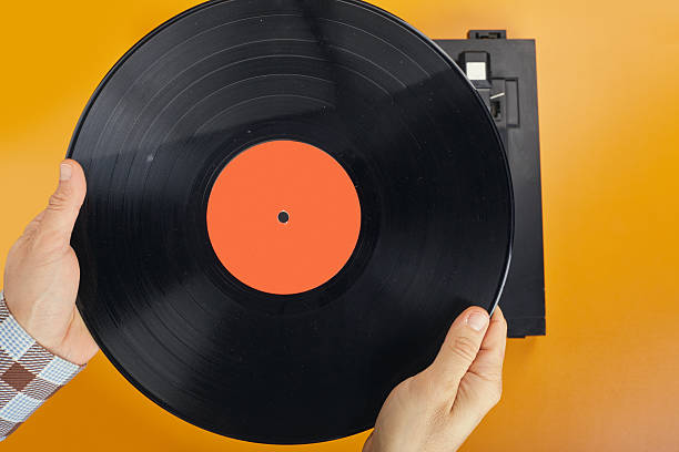 istock A man is holding a heavily dust-covered vinyl record, ready to play it on a turntable 2250381820