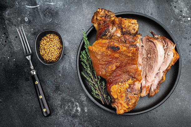 istock Bavarian roasted knuckle shank with seared rind texture, juicy cross-section and defined muscle fibers presented on matte black dish with thyme. 2250384515