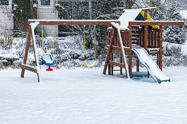 Frozen blizzard snow storm children's back yard swing, slide and play set. Photo taken in a suburb near the city of Rochester, in western New York State.