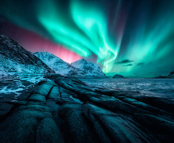 istock Aurora borealis on night starry sky and rocky shore in winter 2250399113