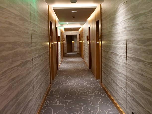 istock Modern luxury hotel corridor interior design with wood panels, marblepatterned walls, abstract floral carpet, and warm ambient lighting. 2250408301