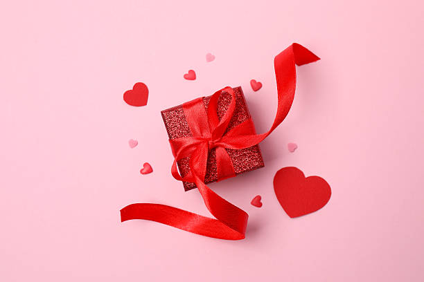 istock Gift box with red hearts on color background 2250411833