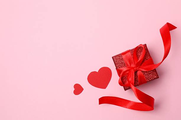 istock Gift box with red hearts on color background 2250411839