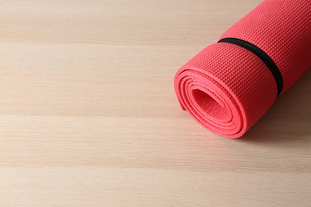 istock Red mat folded into a roll, karemat for camping, on wooden background 2250412068