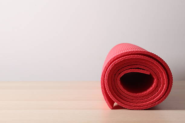 istock Red mat folded into a roll, karemat for camping, on wooden background 2250412069