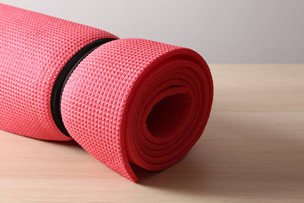istock Red mat folded into a roll, karemat for camping, on wooden background 2250412072