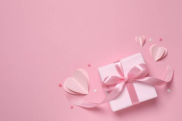 istock Beautiful gift box with pink hearts on color background 2250414114