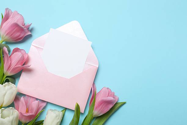 istock Beautiful fresh tulips with pink envelope on color background 2250414746