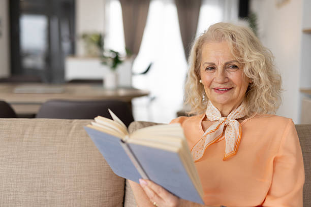 istock Elderly Woman Enjoying a Book on a Comfortable Sofa 2250420375