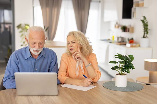 istock Senior couple collaborating on a project at their home 2250420436