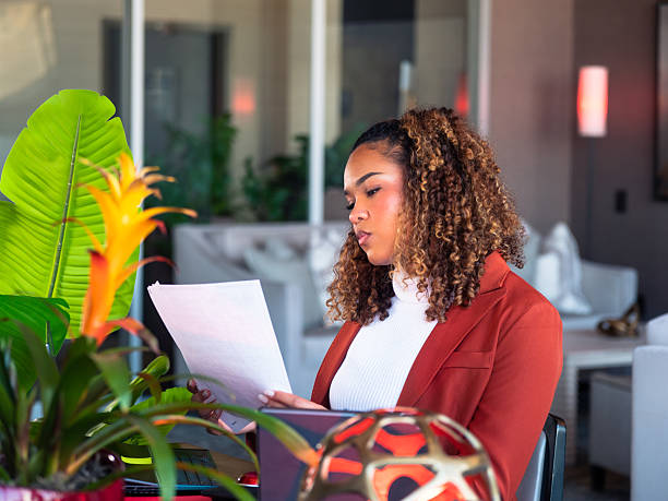 istock Black Woman Reviewing Documents at Office Desk 2250432409
