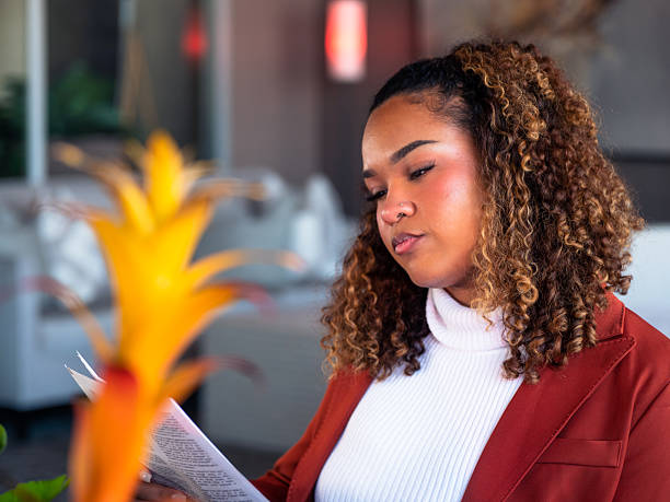 istock Black woman reading a document in cozy setting 2250432416