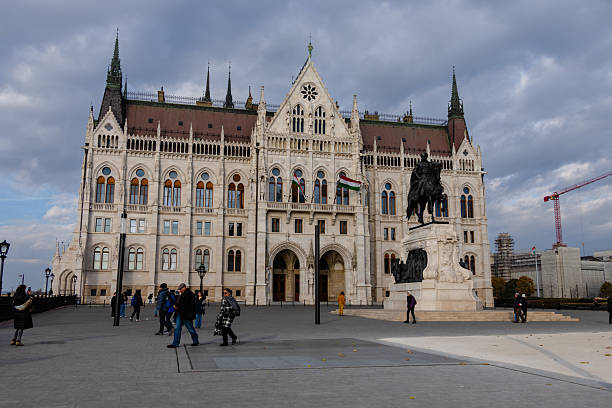 Hungarian Parliament Building in Budapest, Hungary viewed from the water with the Danube River in the foreground.