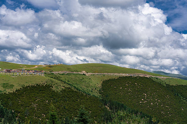istock Beautiful green hills under a cloudy sky with some buildings 2250441074